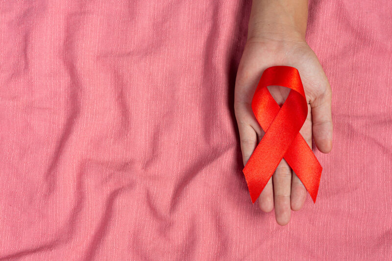 Woman hand holding red ribbon HIV awareness concept World AIDS D